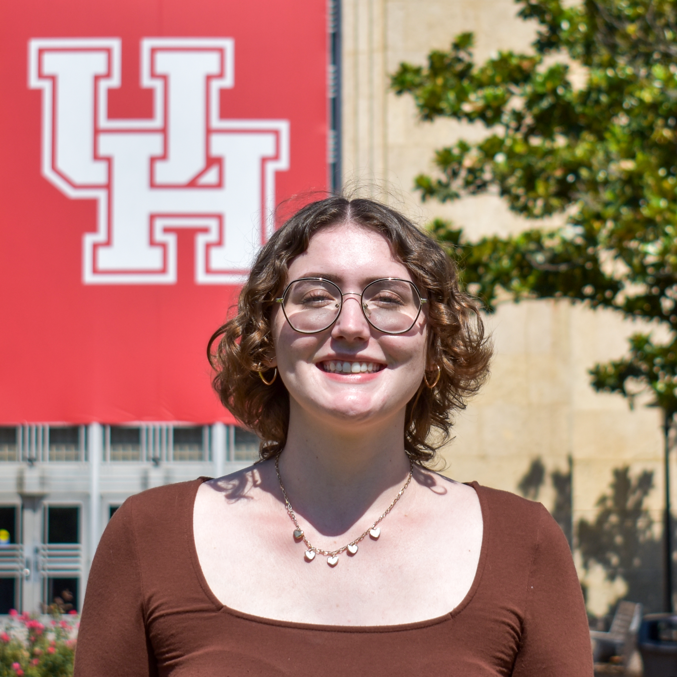 female student in front of UH banner