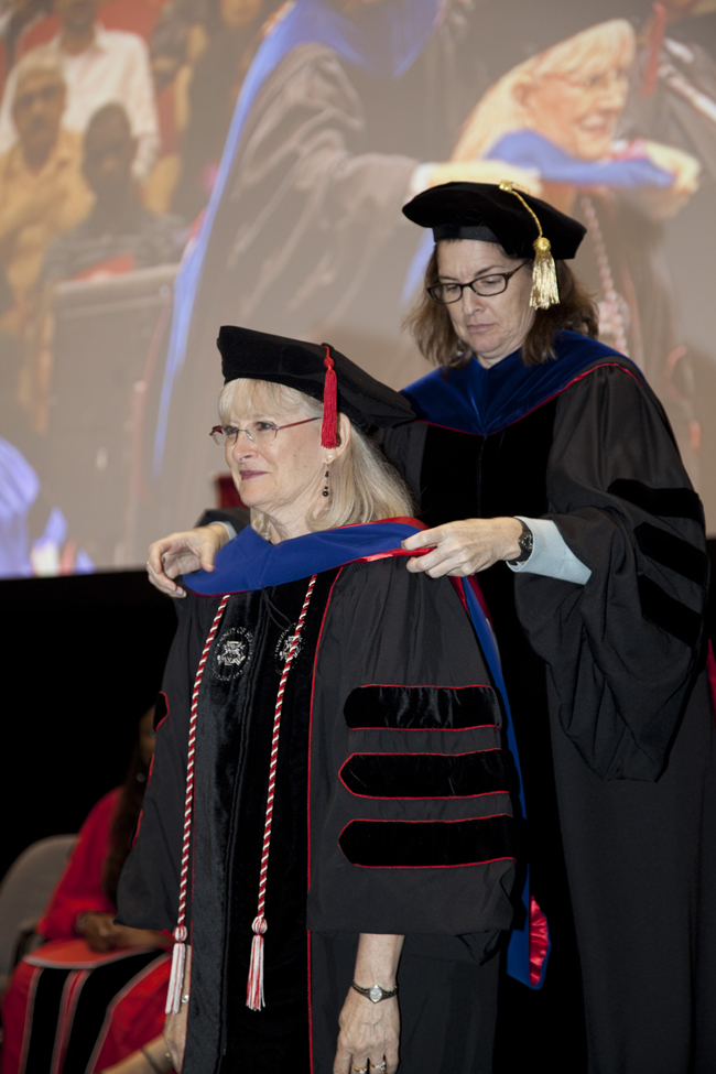 Debbie Harwell, Ph.D being hooded by Dr. Storrs