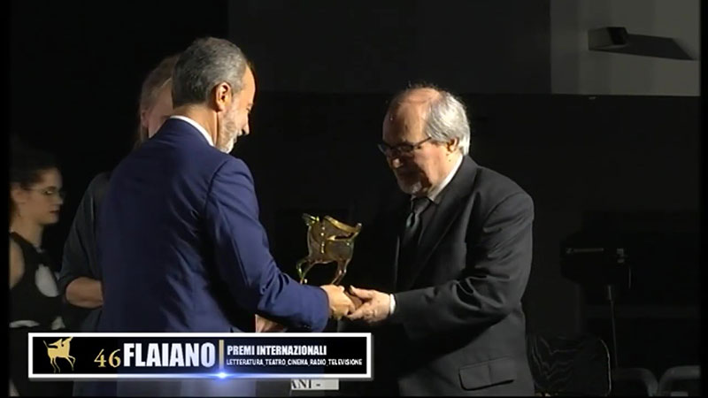 Alessandro Carrera on stage receiving award statue 