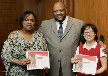 Elwyn Lee, vice president for student affairs, congratulates staff members Barbara Newsome (left) and Kim Tran