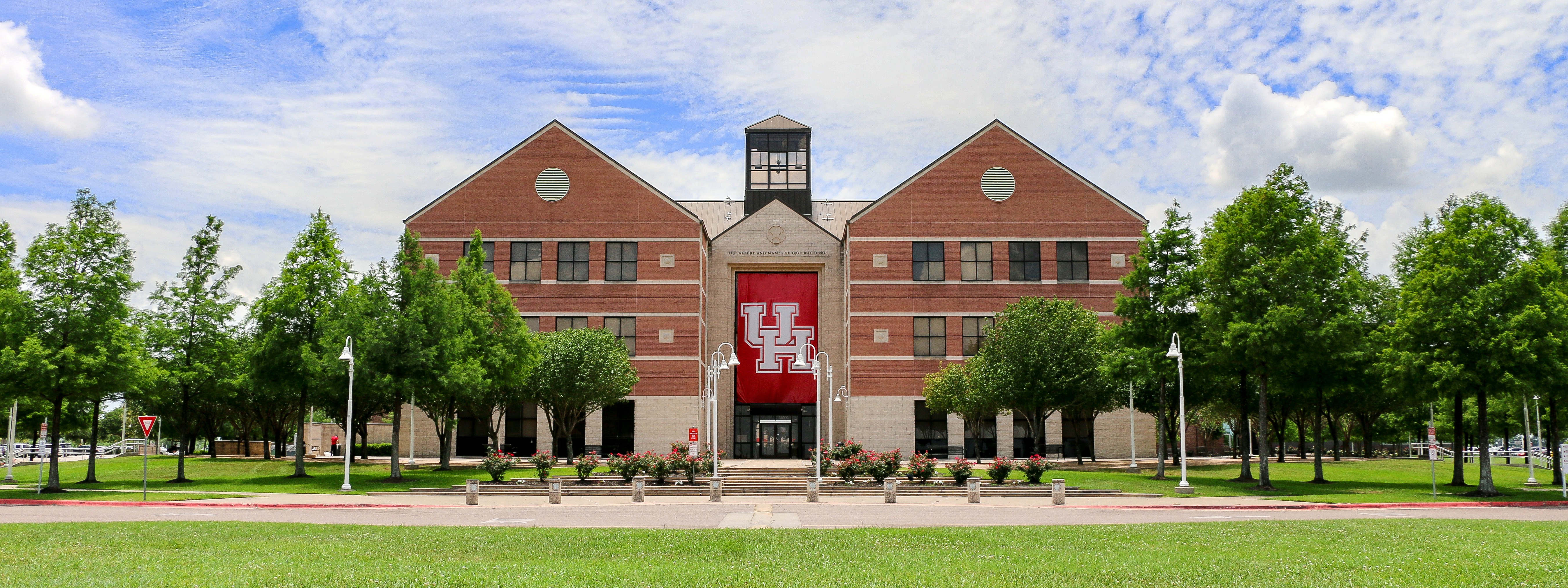 Landscape photo of a brown building with a large red banner on the front