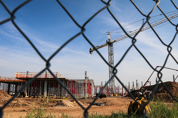 Construction crane behind a chain link fence