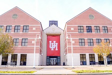 Front of three story brick building with a large red banner
