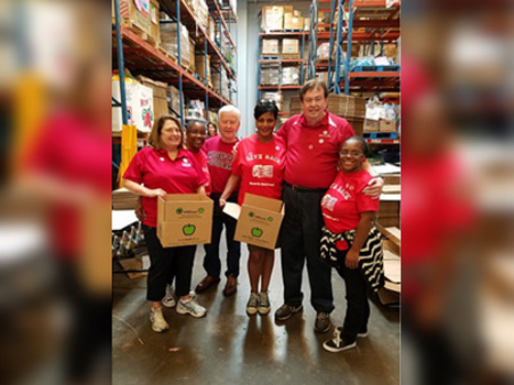 People in red shirts standing together in a warehouse