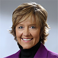 A portraif of a smiling woman with short blonde hair.