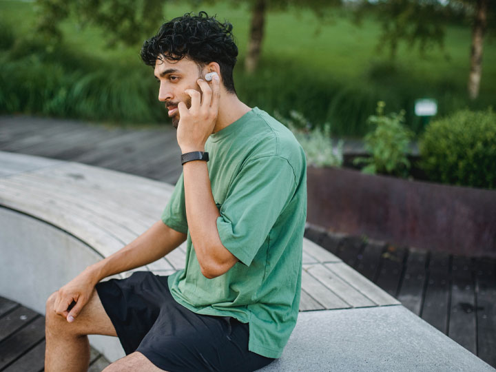man sitting on a bench with his cell phone on his ear