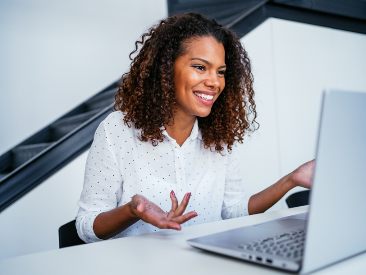 woman talking to her computer sitting at a desk
