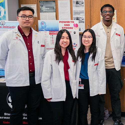 pharmacy students in white coats at health fair