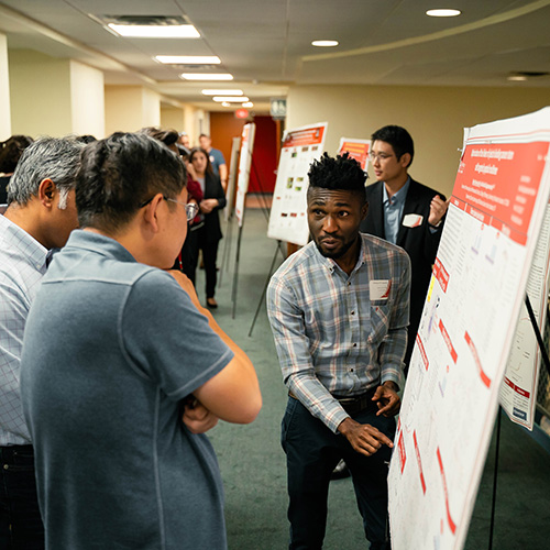 Ph.D. student presents his abstract to symposium participants
