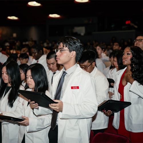 pharmacy students read oath in white coats