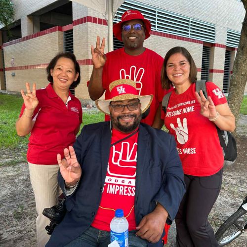 four staff wearing cougar first impression shirts outside