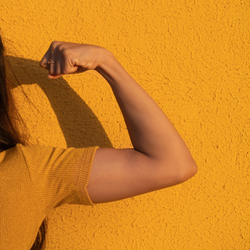 flexing arm with a shadow cast on a wall behind the arm