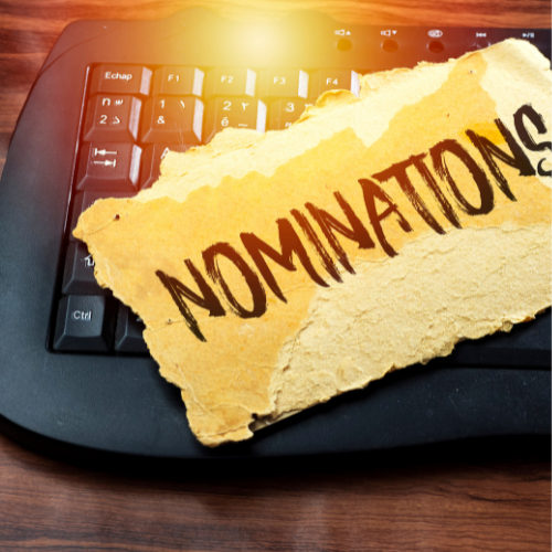 keyboard with a paper on top with word Nominations written in all Caps