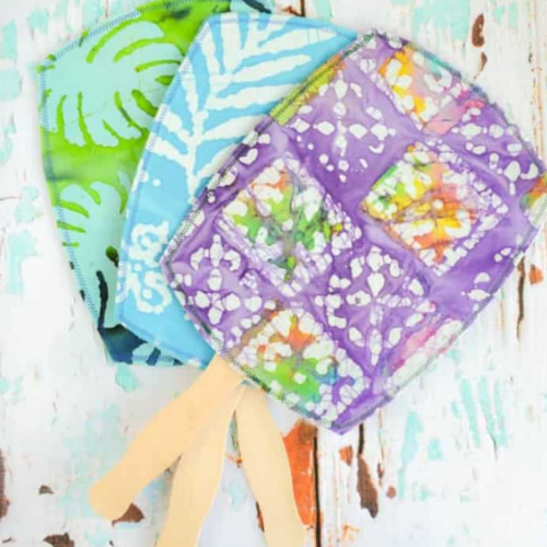 three decorative paddle fans laying on a table