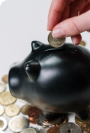 A coin being dropped into a piggy bank