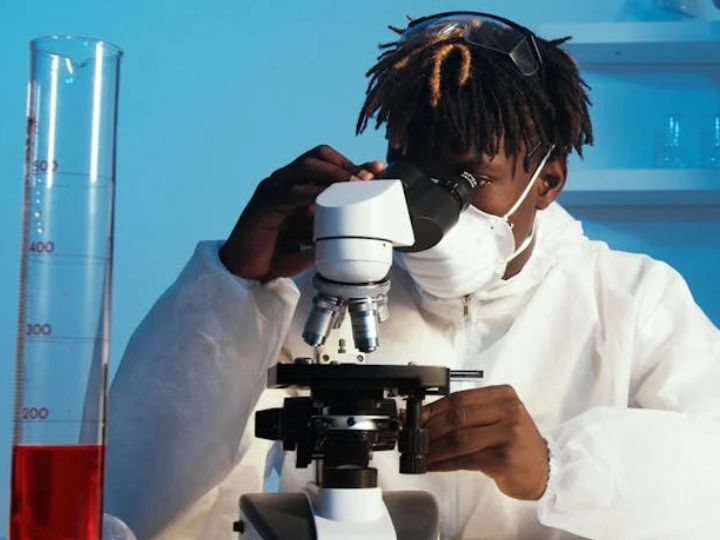 Researcher looking into microscope