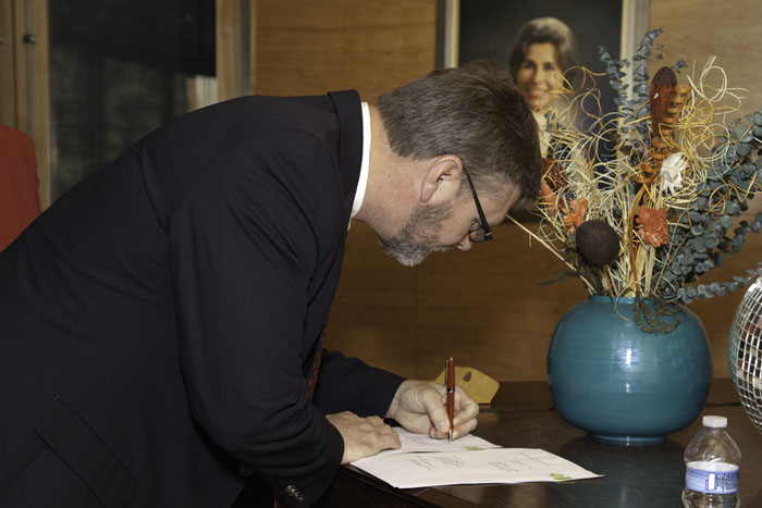 Dr. Charles Layne signing the scholarship documents