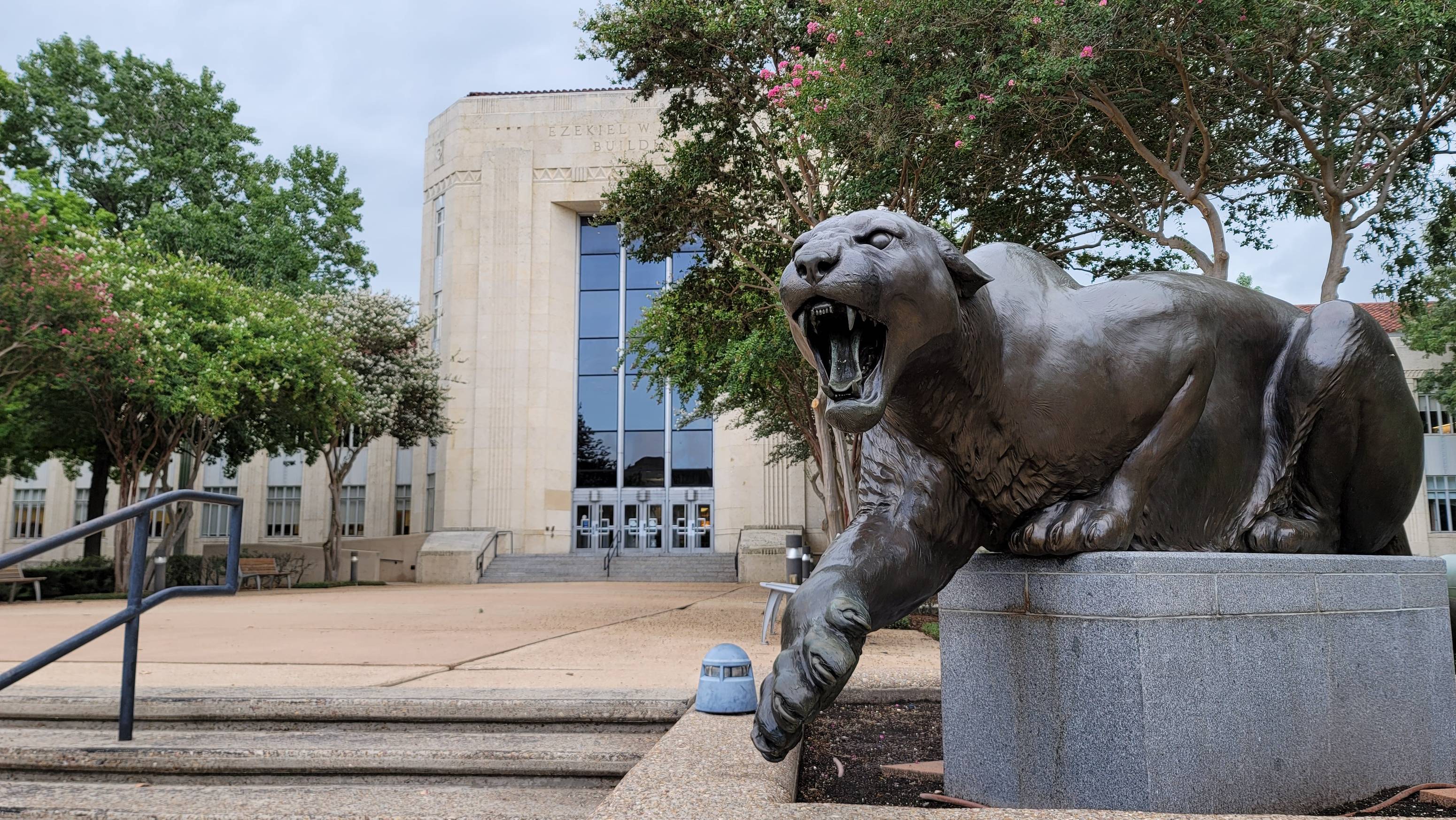 A photo of the Ezekiel Cullen Building with a statue of Sasha in the foreground.