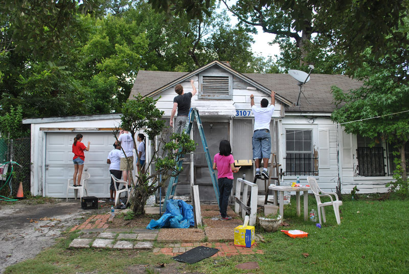 Volunteers painting a house