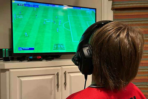 Child with headphones watching a video game
