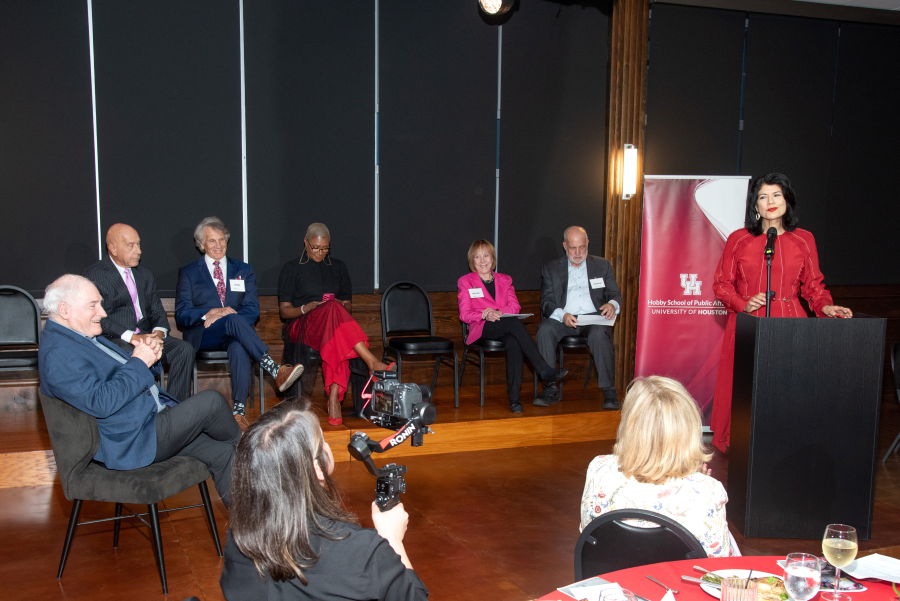 Women in a red dress speaking at the podium