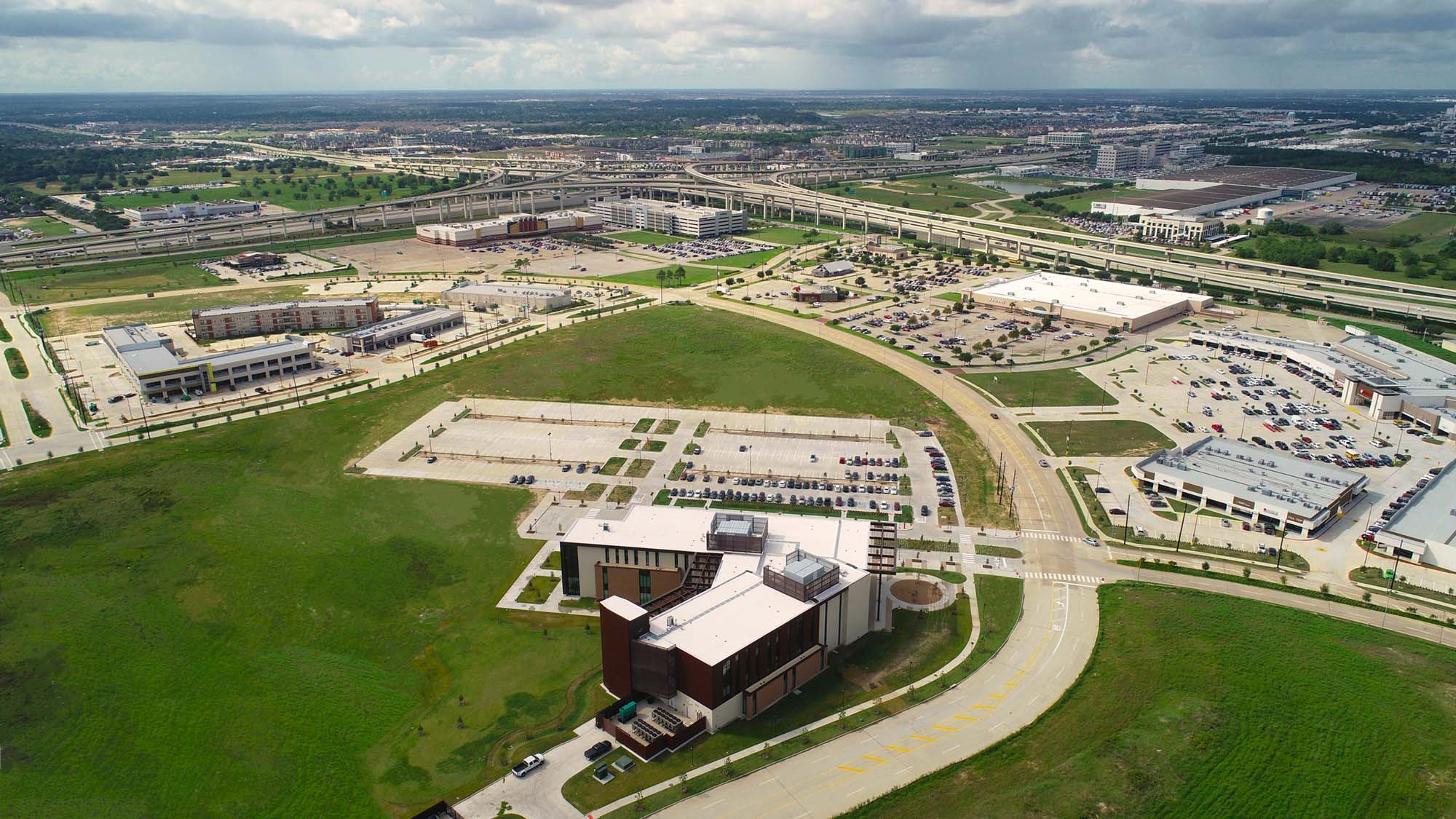 Ariel view of the Katy Academic Building with the Interstate 10 and Highway 99 intersection in the background.