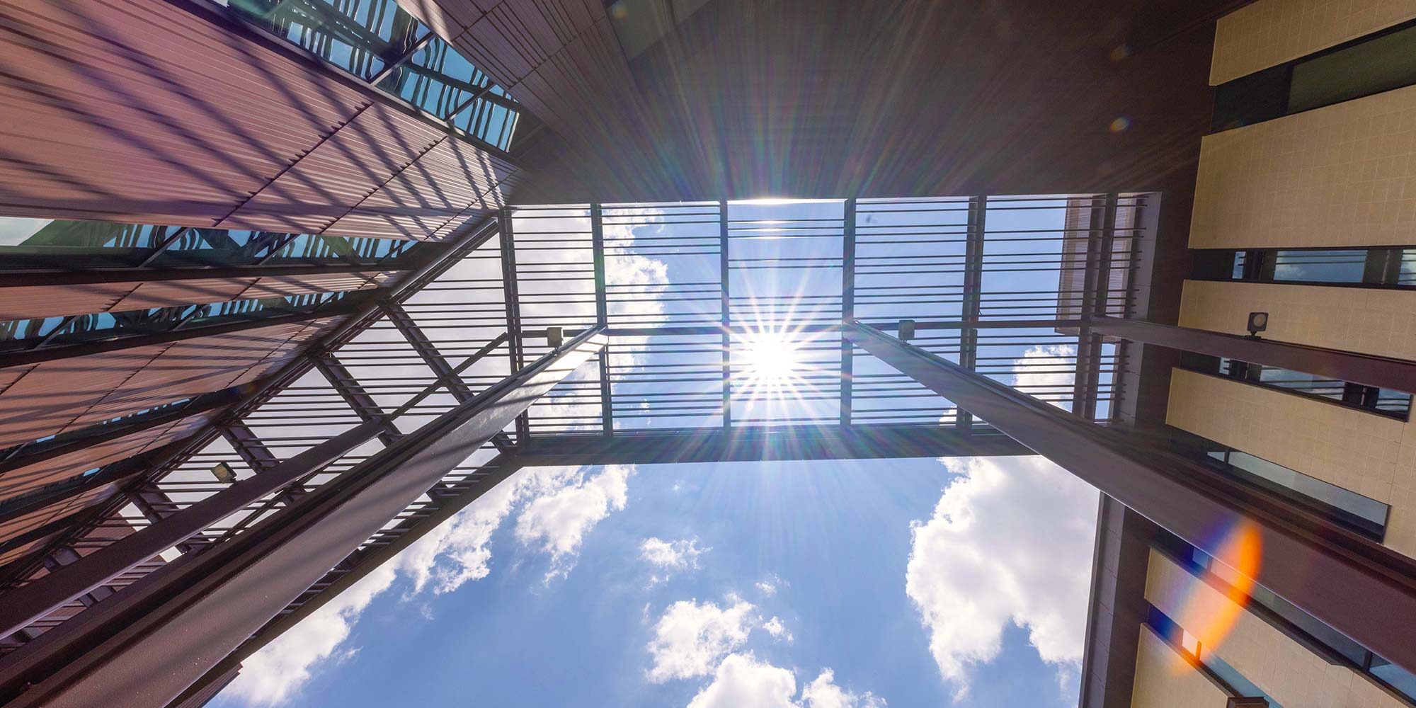 Sunlight shines through the awning overhead. The outline of the awning is visible along the brick and metal walls.