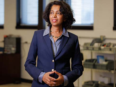 A protrait of an Indian woman in a dark blue business suit looking to the left.