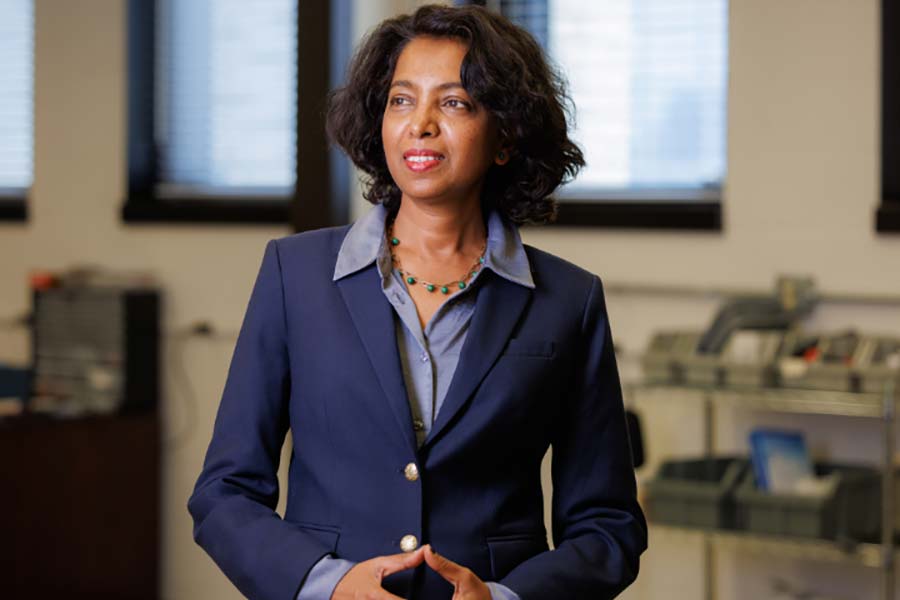 A protrait of an Indian woman in a dark blue business suit looking to the left.