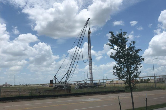 A crane and empty land marking early stages of construction