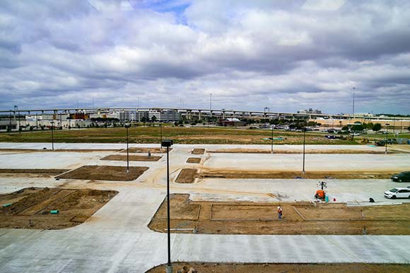 An unfinished parking lot in front of a highway