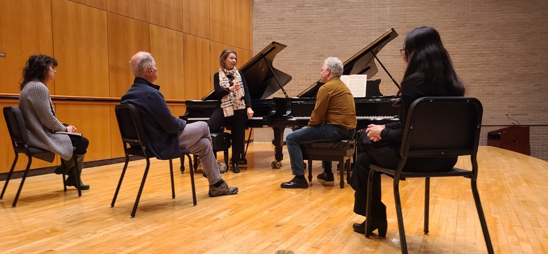 adults gathered around a piano in a group class