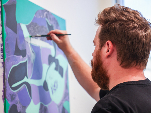 a man working on an oil painting