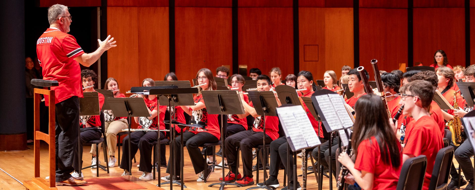 David Bertman in a red UH shirt conducting the High School Honor Band Project