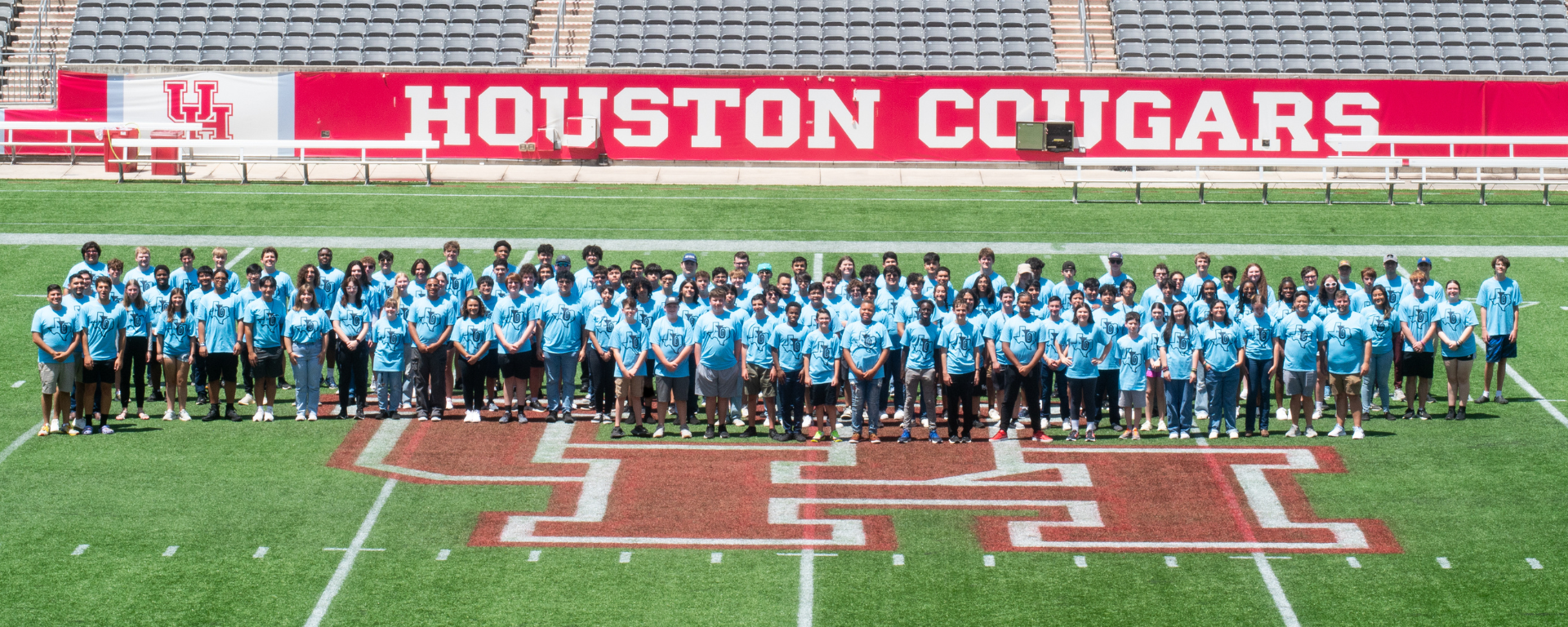2023 Texas Low Brass Academy participants posing for a group photo on the University of Houston football field