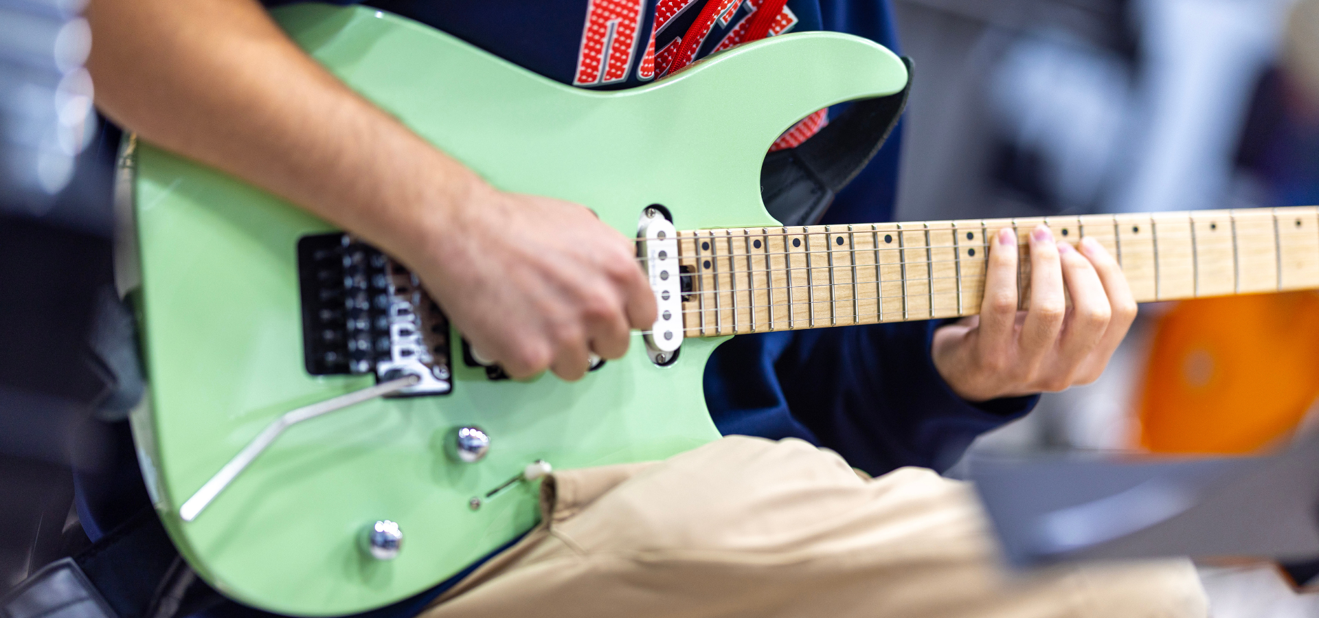 Musician playing a mint green electric guitar