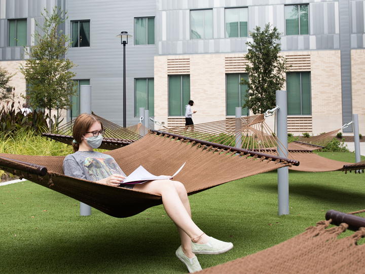 Student sitting on hammock at quad