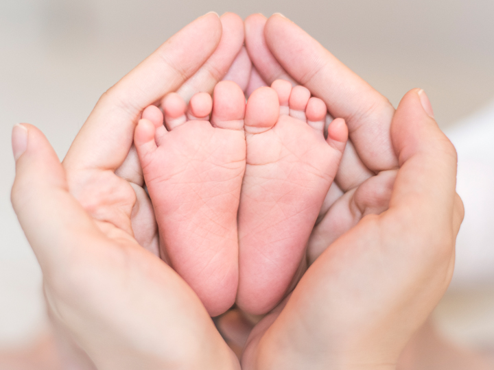 Baby feet with grownup hands 