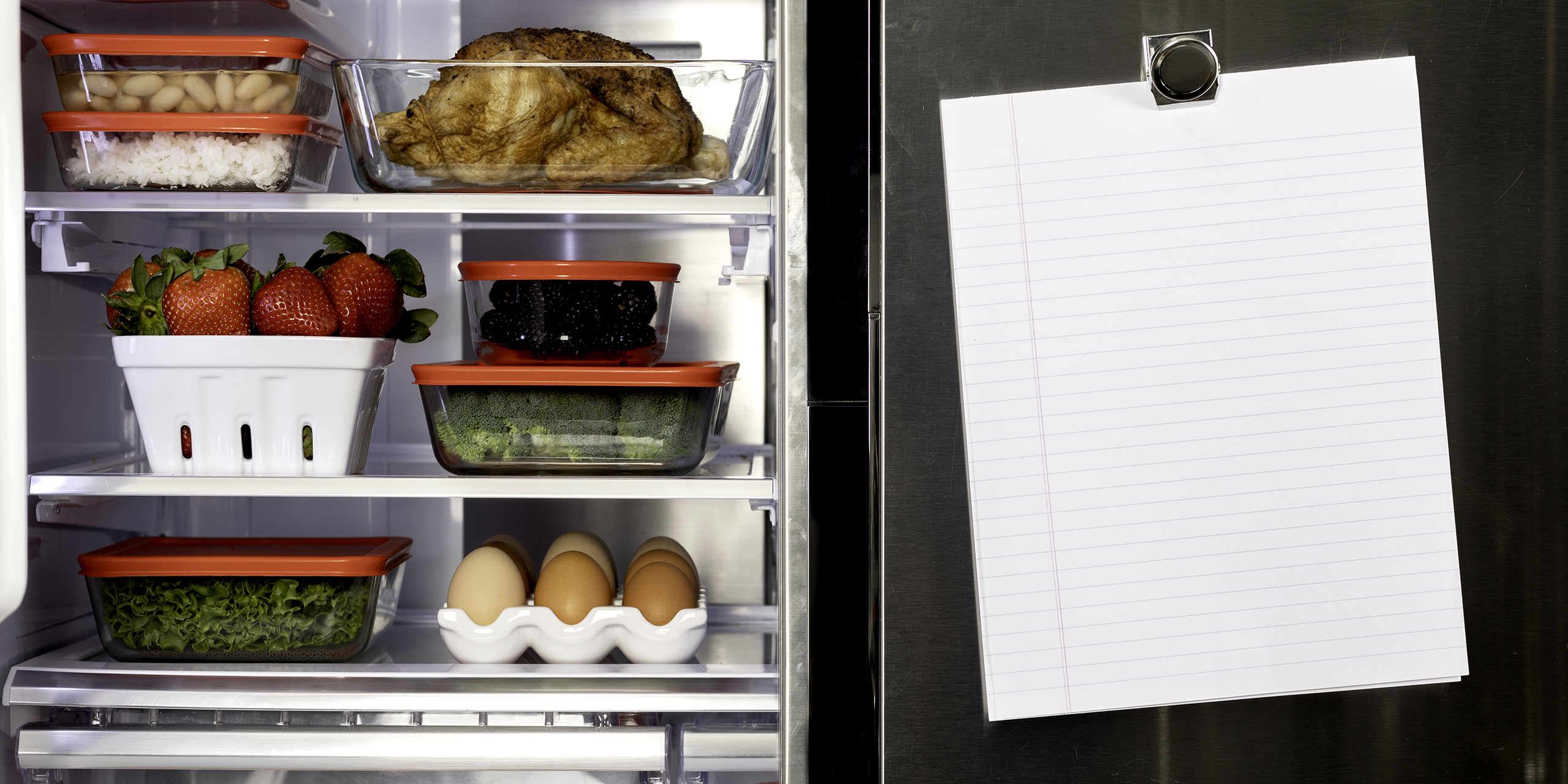 Refrigerator with one door open revealing food, one door closed, and a piece of paper attached with a magnet