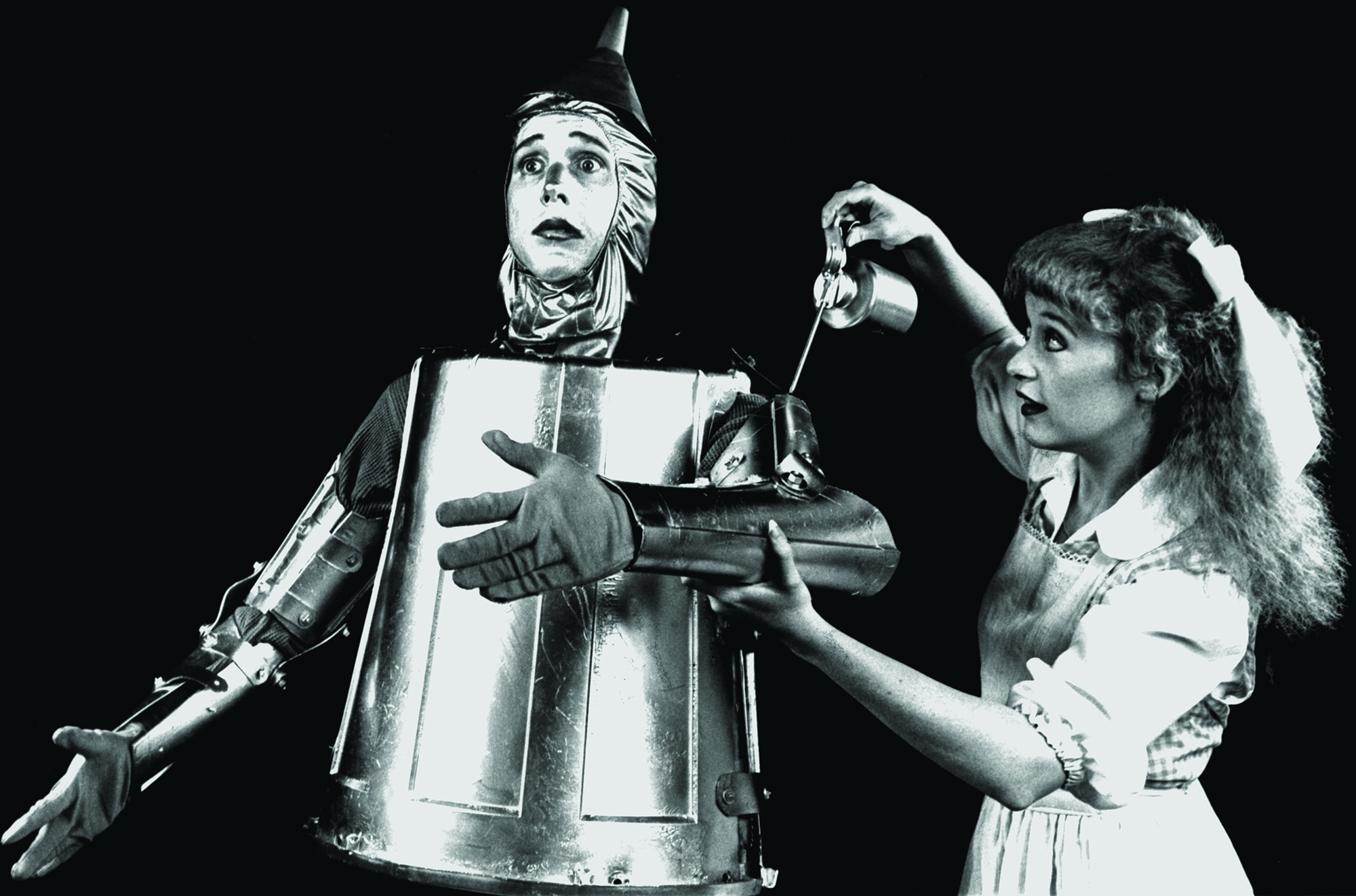 Dorothy giving the Tin Man a shot of oil in the arm