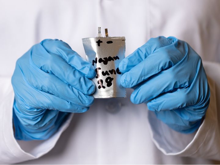 A bendable batter prototype demo with a researcher's blue-gloved hands.