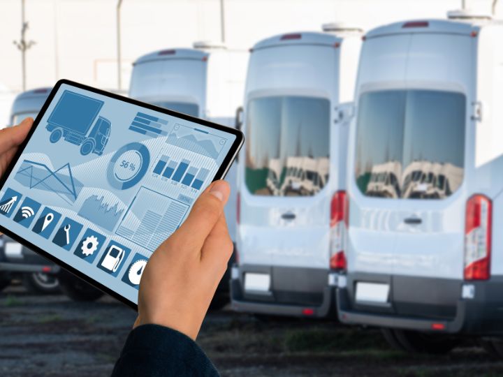 Person with computer in front of a fleet of cars for carbon management Person with computer in front of a fleet of cars for carbon management