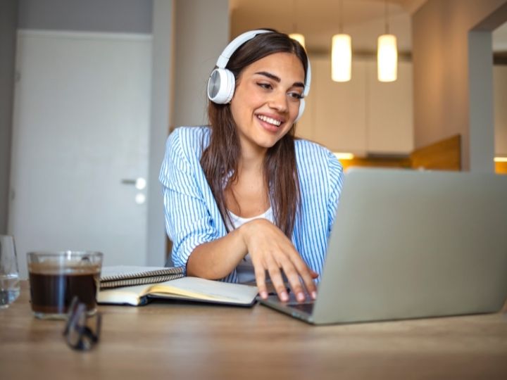 Photo of student smiling as she studies at her computer