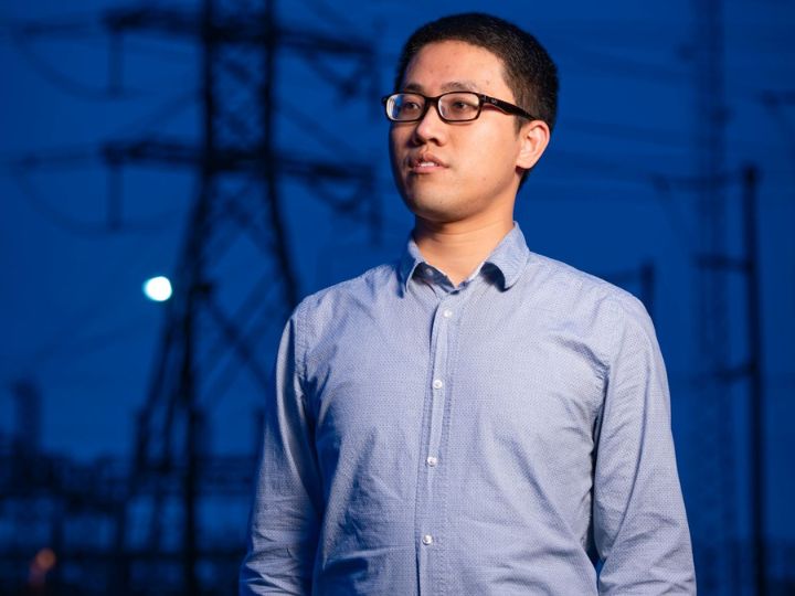 xingpeng li, assistant professor at the University of Houston, with a backdrop of electrical power systems.