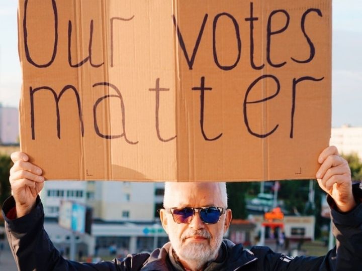 Picture of man holding sign that says all votes matter Picture of man holding sign that says all votes matter