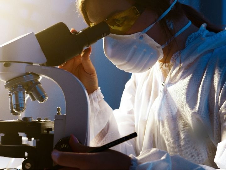 Photo of a scientist looking into a microscope Photo of a scientist looking into a microscope