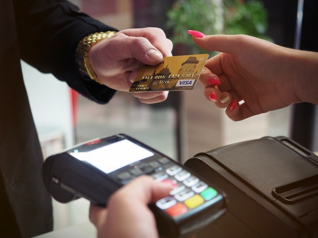 Photo of customer paying for purchase with credit card Photo of customer paying for purchase with credit card