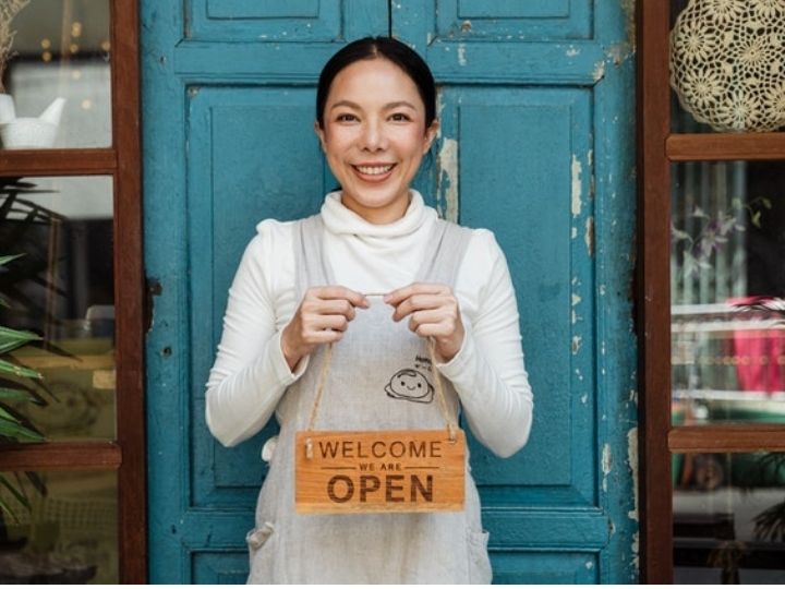 Woman store owner welcoming customers Woman store owner welcoming customers