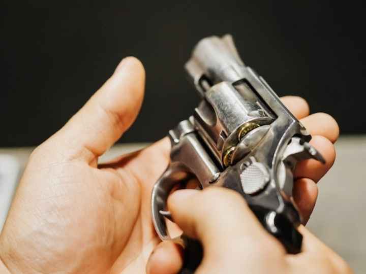 Photo showing a small gun cradled in a person’s hands Photo showing a small gun cradled in a person’s hands