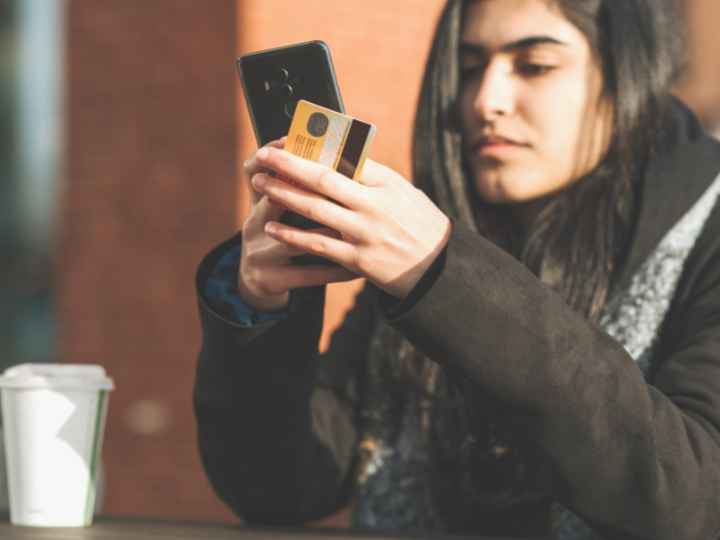 Photo of woman using her cell phone to shop online Photo of woman using her cell phone to shop online
